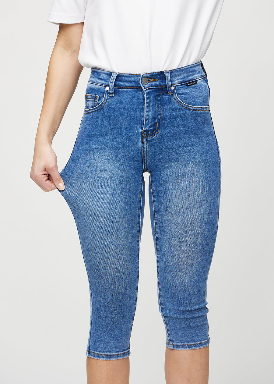 Model strækker caprisene ved låret for at vise stretch.