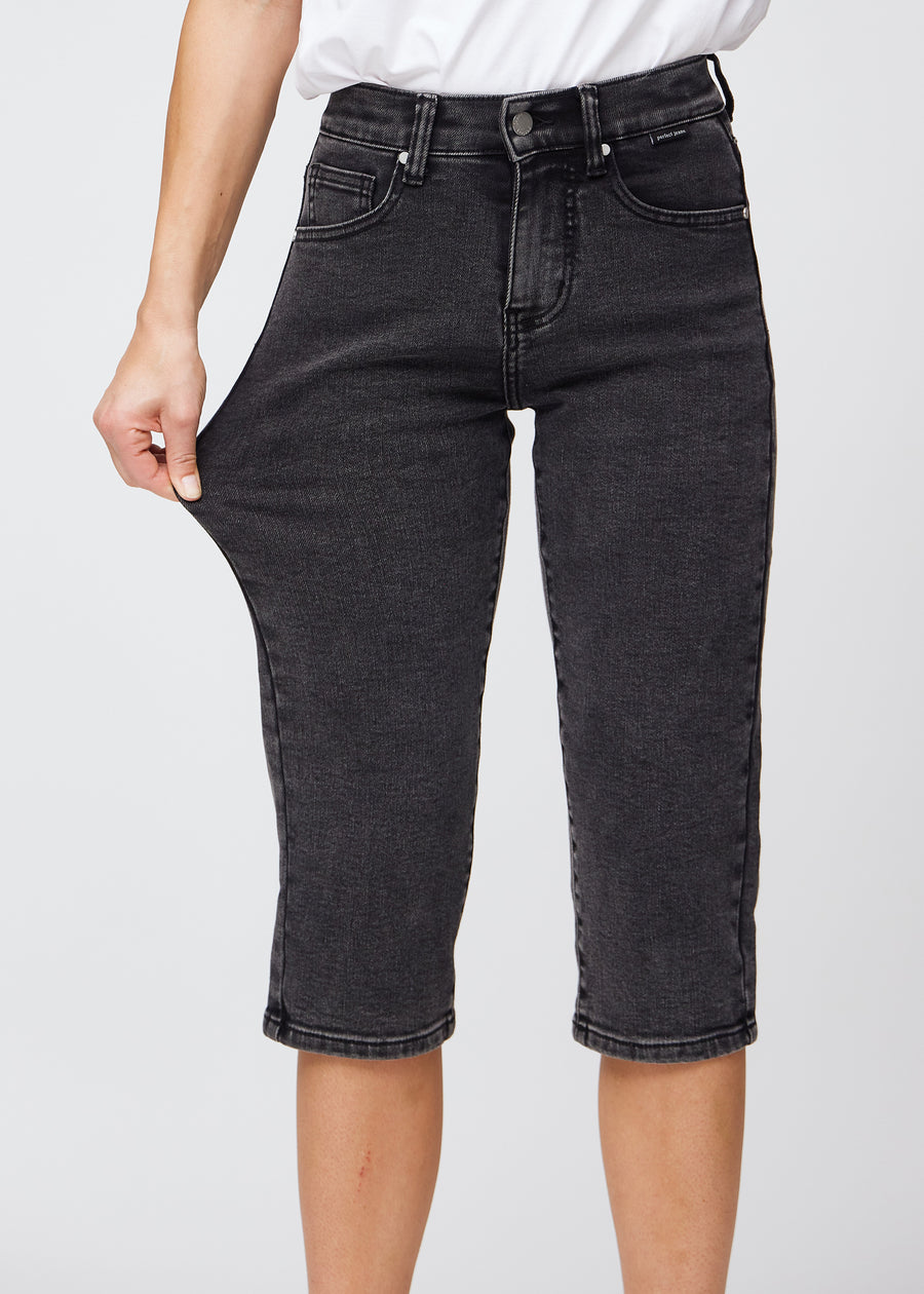 Model strækker caprisene ved låret for at vise stretch.