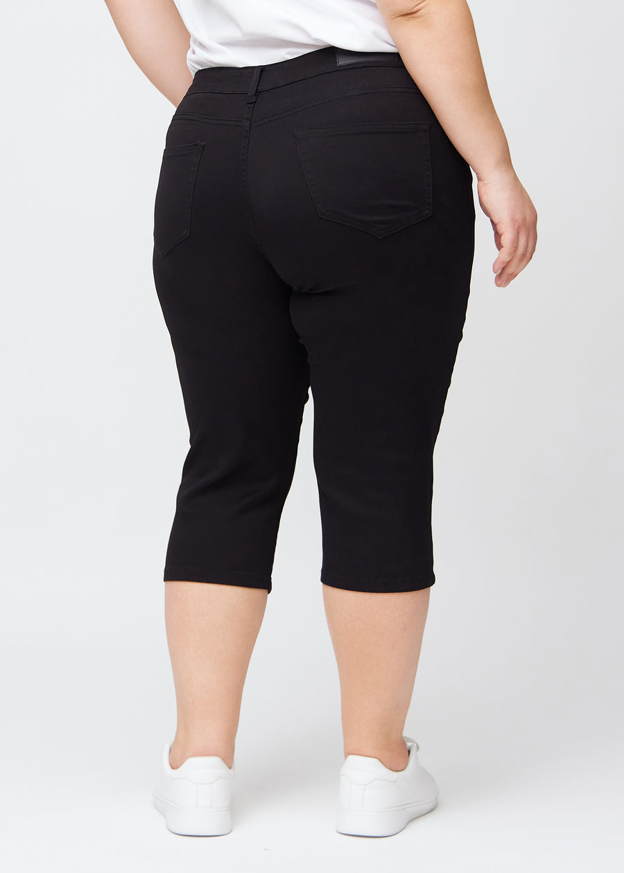 Sorte slim capris set bagfra på en plus-size model – tydeligt billede af hele produktet og lommer.