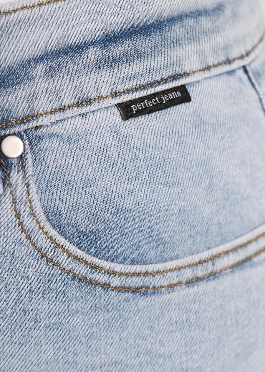 Forlommen på et par lyseblå denim jeans, hvor man kan se logoet. på en plus-size model.