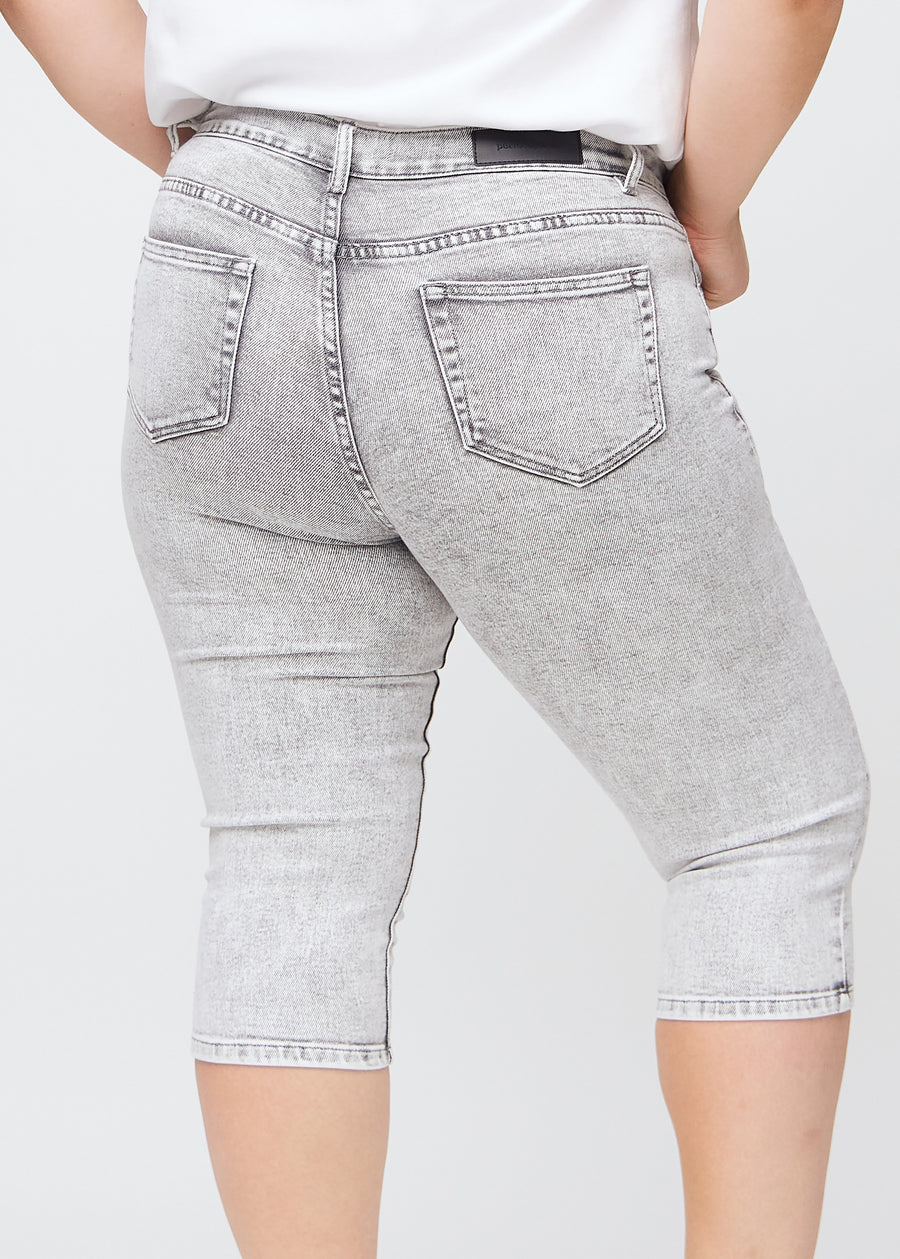 Lysegrå denim skinny capris set bagfra tæt på en plus-size model for at vise detaljer.