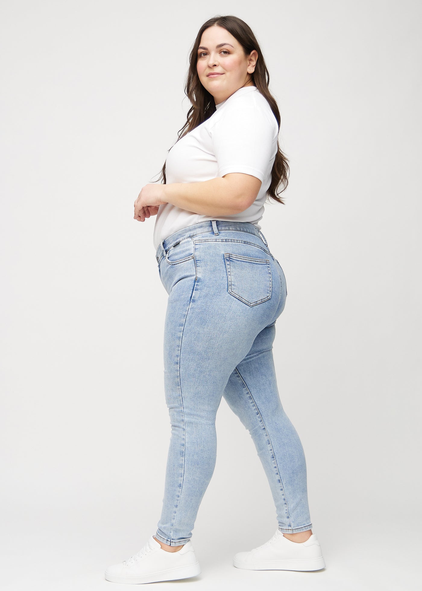 Lys denim skinny jeans set fra siden på en plus-size model.