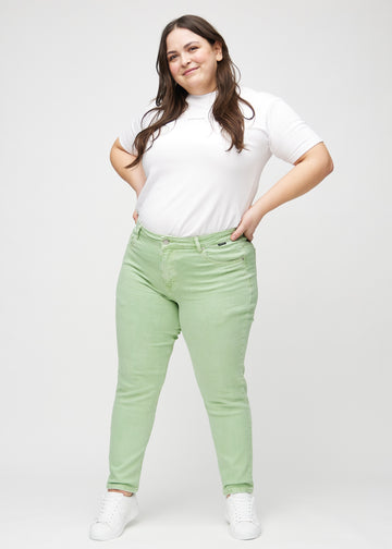 Fuldt billede af en plus-size model i lysegrønne slim jeans.