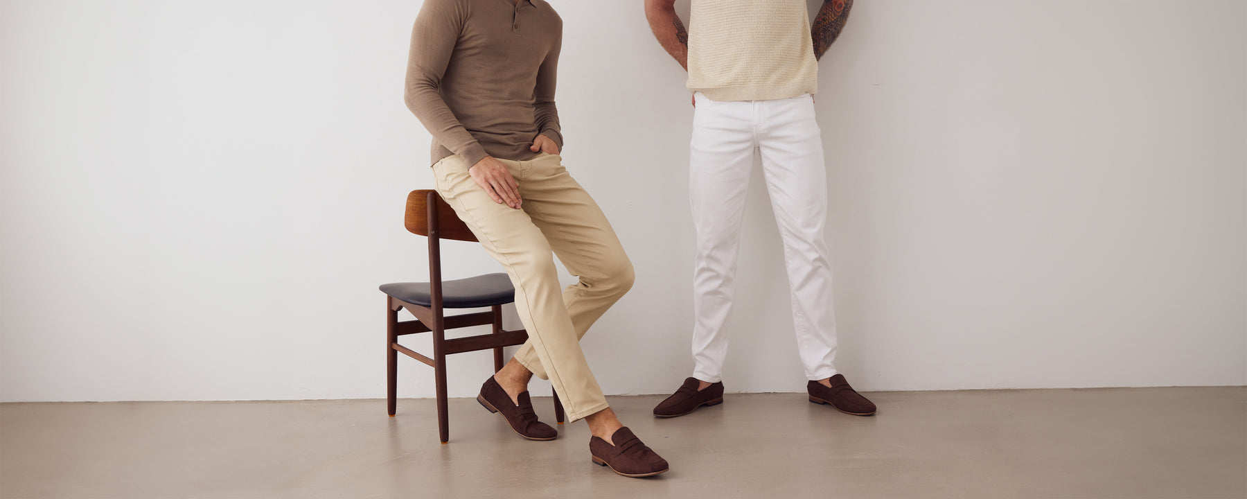 To mænd iført hvide og beige jeans.