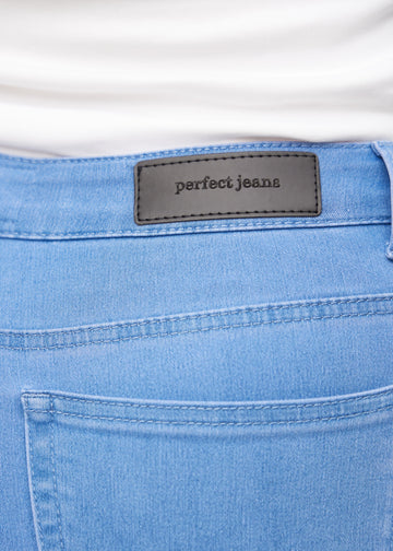 Nærbillede af blåt jeansmateriale med Perfect Jeans læderpatch bagpå i taljen, på en plus-size model.