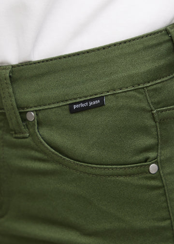 Nærbillede af grønt jeansmateriale med Perfect Jeans logoetiket ved forlommekanten.