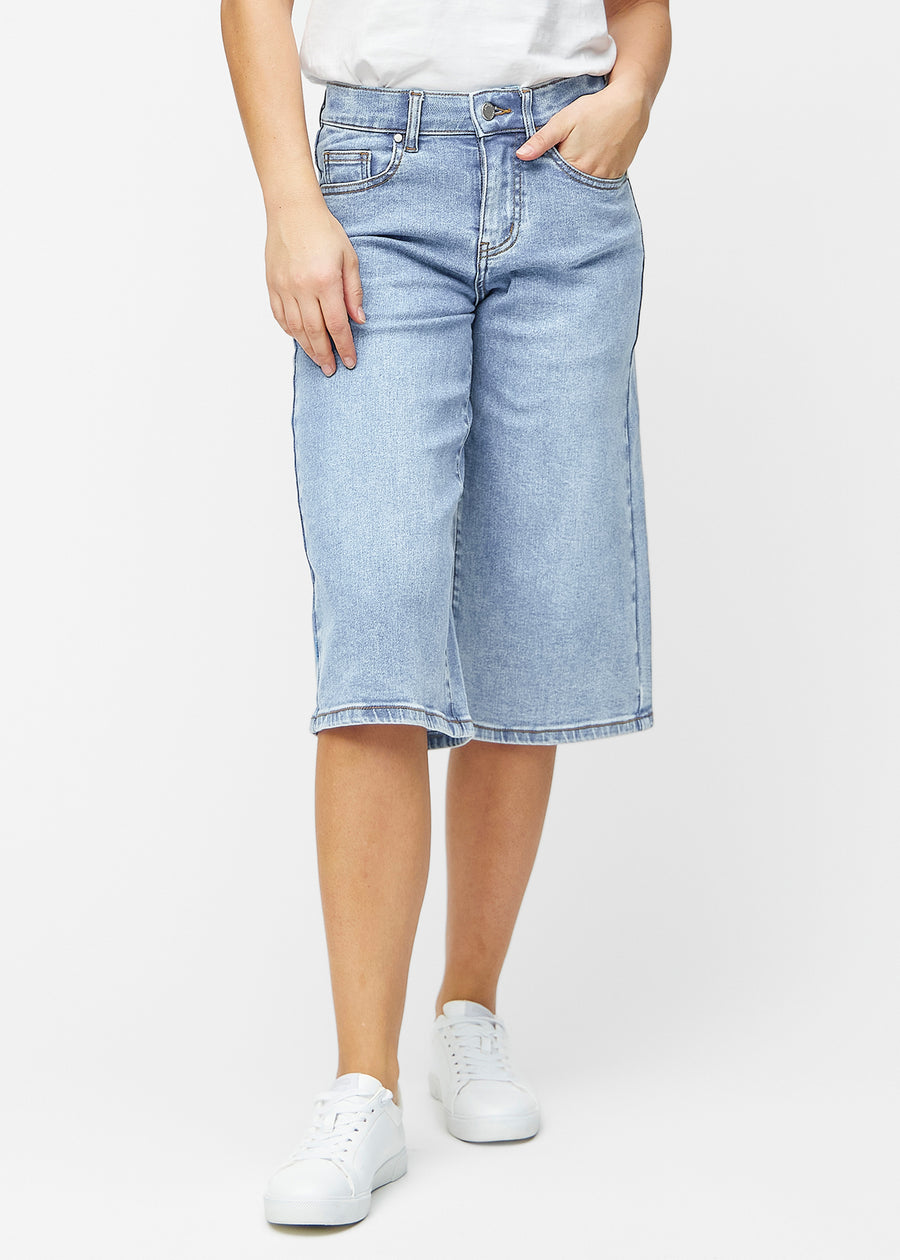 Loose, light blue denim capris in the colour Waves, sitting at the hips and falling loosely over the thighs to just below the knee, seen from the front.