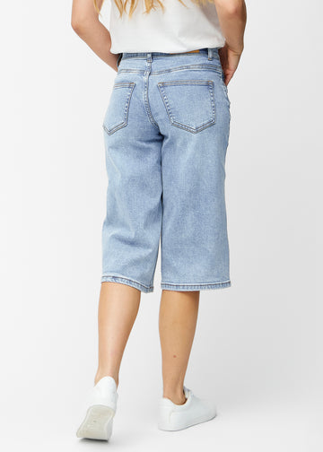Loose, light blue denim capris in the colour Waves seen from the back, showing fit and length.