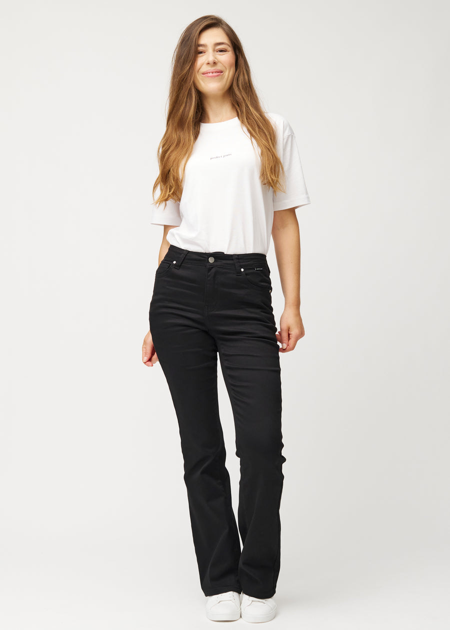 Black mid-rise bootcut jeans in Ravens. Full-length view of a model wearing the jeans.