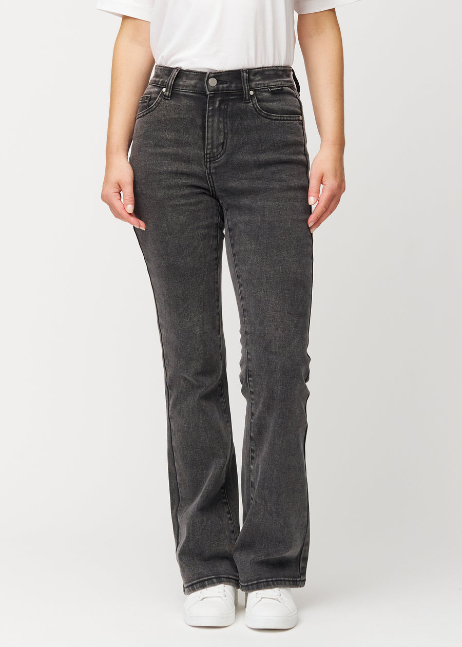 Dark grey mid-rise bootcut jeans in Shadows. Front view on a model, fitted through the hips and thighs with a gentle flare at the hem.