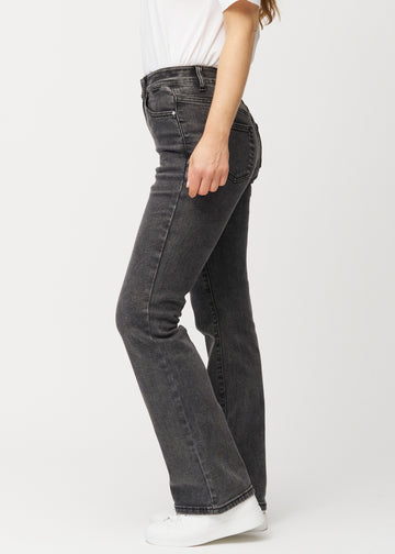 Dark grey mid-rise bootcut jeans in Shadows. Side view on a model.