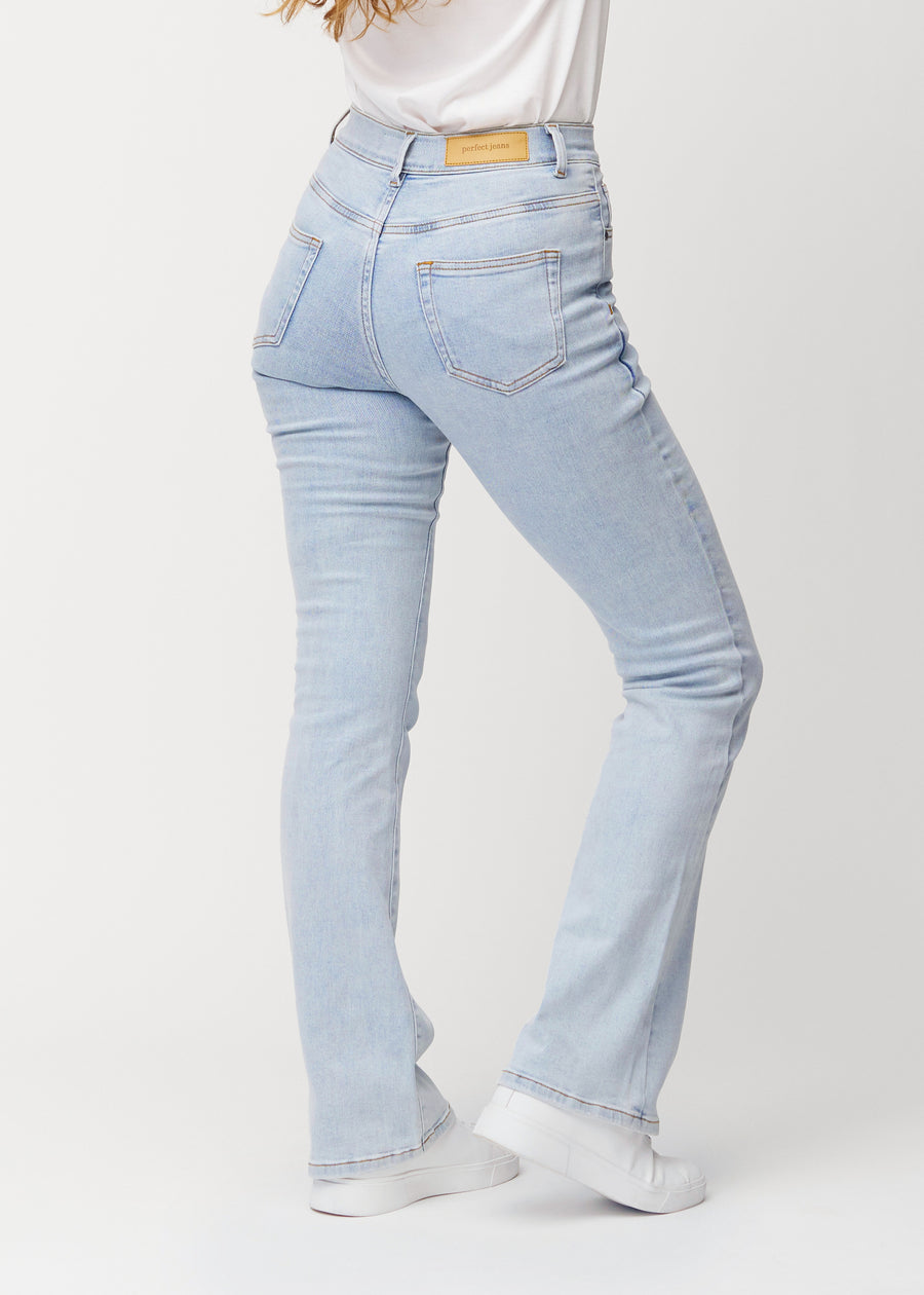 Light blue mid-rise bootcut jeans in Waves. Back view on a model, showing the full fit.