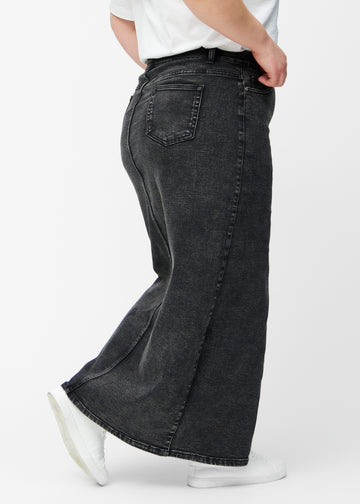 Lang, mørkegrå denimnederdel i farven Shadows med regulær pasform set bagfra på plus-size model, så hele nederdelens længde kan ses.