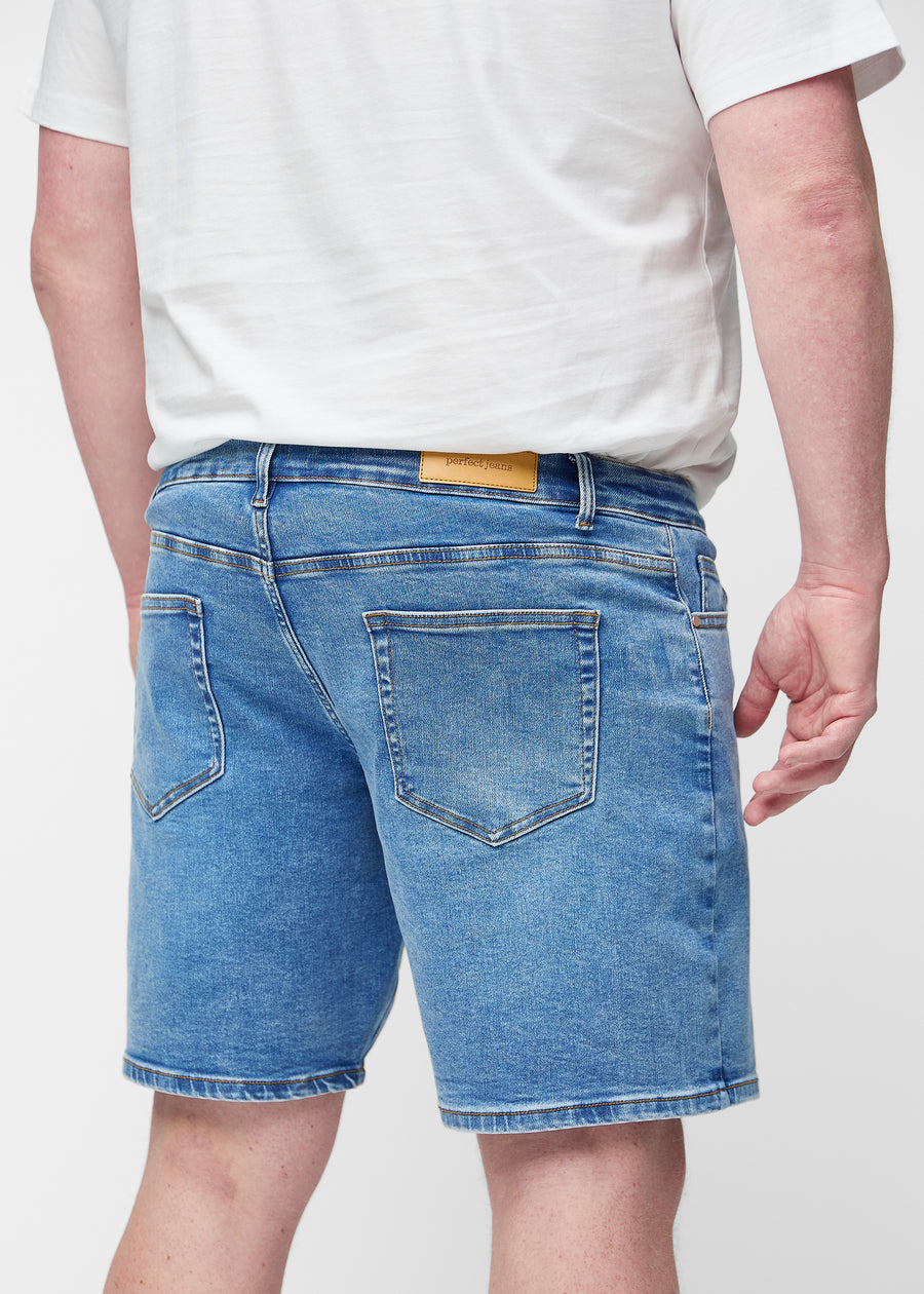 Blue denim shorts for men in the colour Rivers seen from the back close up on a plus-size model to show fit and details.