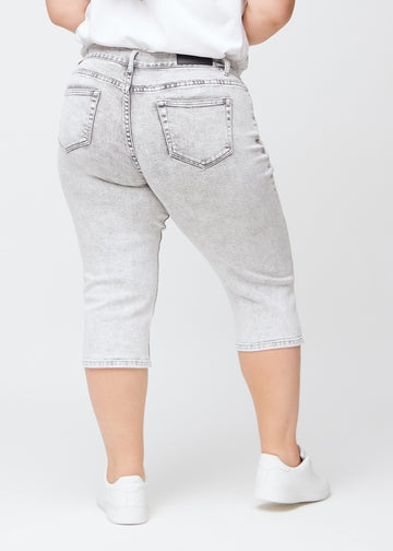 Light grey denim regular capris seen from the back on a plus-size model, so the entire product can be seen.
