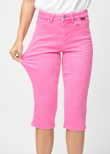The model stretches the capris at the thigh to show the stretch.