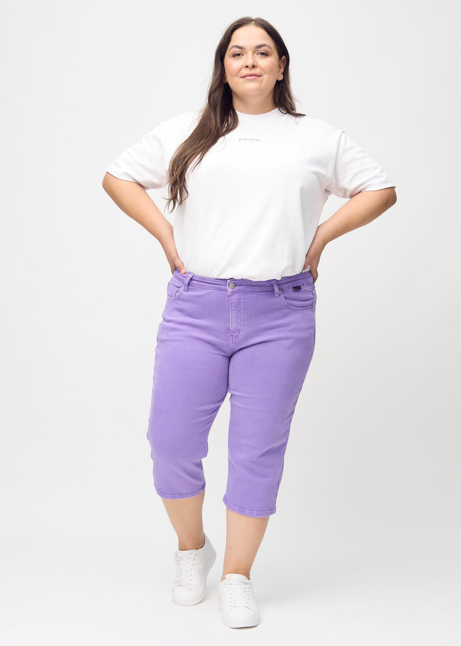 Full-length image of a plus-size model in purple regular capris.
