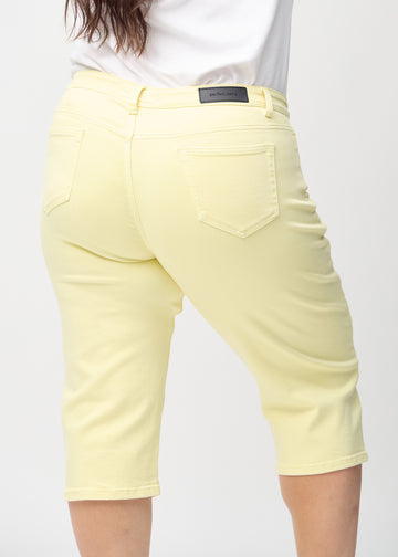 Light yellow regular capris seen from the back close up on a plus-size model to show details.