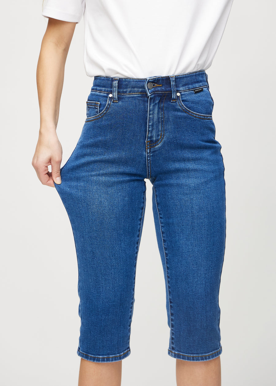 The model stretches the capris at the thigh to show the stretch.