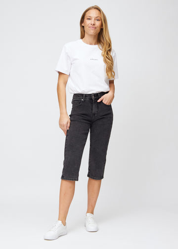 Full image of model in dark grey denim regular capris.