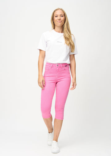 Skinny capris for women in pastel pink fabric, color Flamingos. Full-length view of a model wearing the capris.