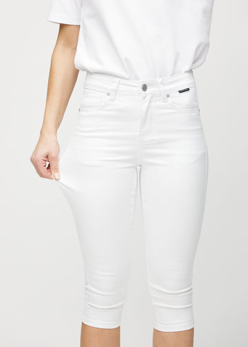 Skinny capris for women in white fabric, color Marguerites. A model stretches the fabric to demonstrate its flexibility.