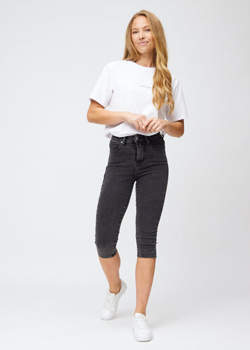 Skinny capris for women in dark grey denim, color Shadows. Full-length view of a model wearing the capris.