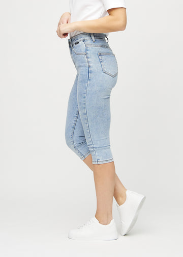 Skinny capris for women in light blue denim, color Waves. Side view on a model, showing the fitted cut.