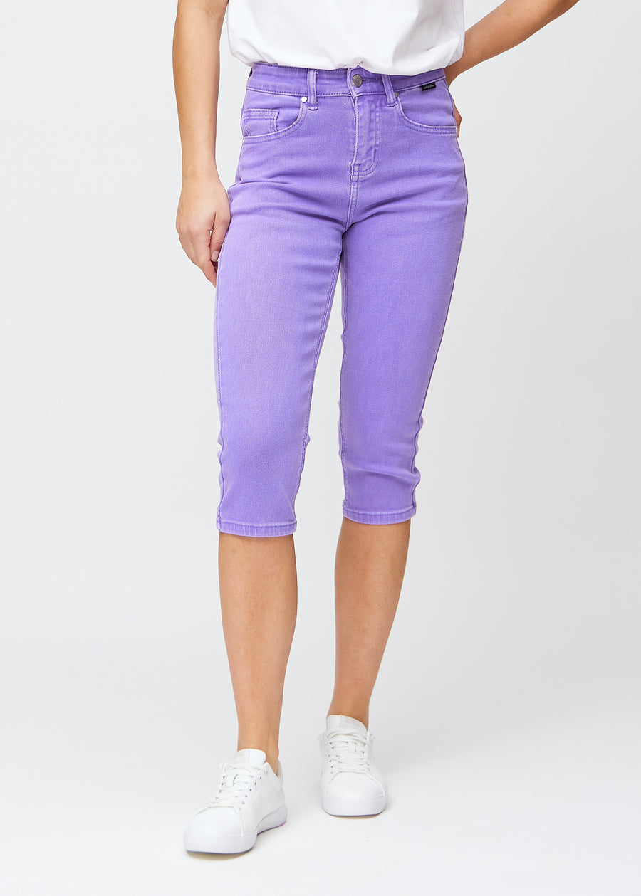 Slim capris for women in pastel purple jeans fabric, color Lavenders. Front view on a model, showing the fitted cut ending just below the knee.