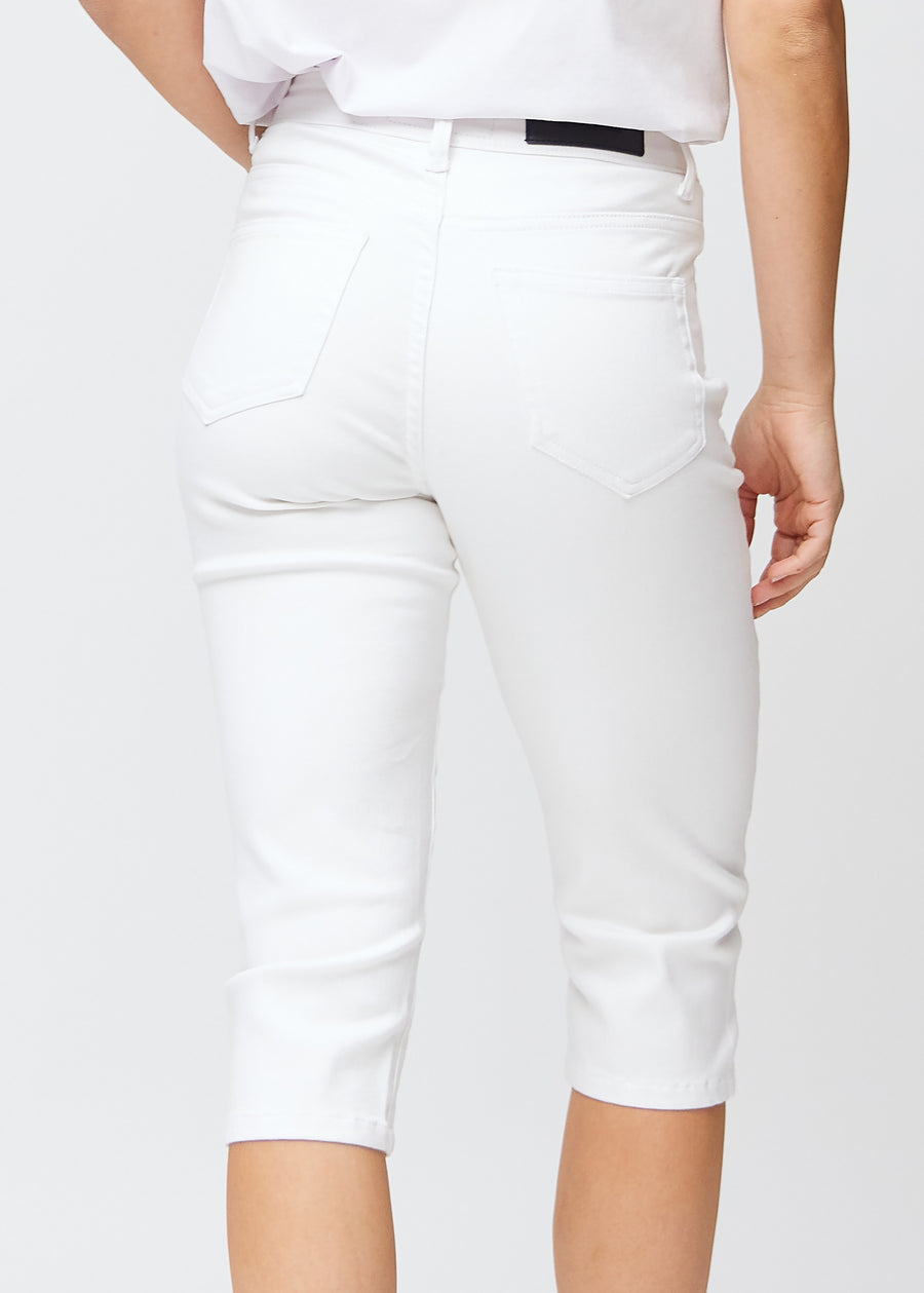 Slim capris for women in white jeans fabric, color Marguerites. Close-up from behind on a model, highlighting the back pockets and stitching.