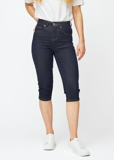 Deep dark blue denim capris for women in the colour Midnights with a slim fit, tailored from the hips to below the knee, seen from the front.