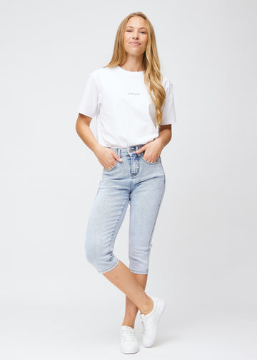 Full image of model wearing light blue denim slim capris.