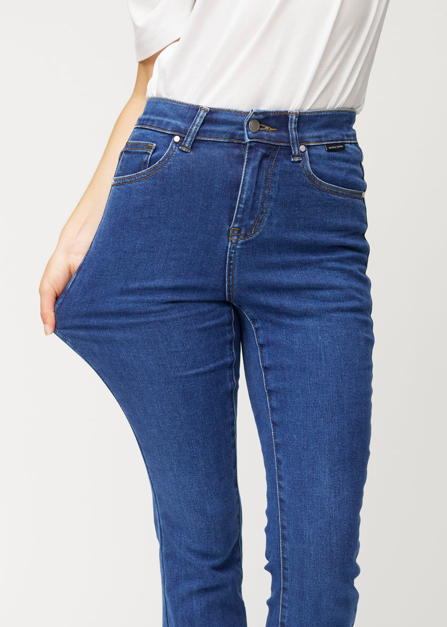 Model strækker jeansene ved låret for at vise stretch.
