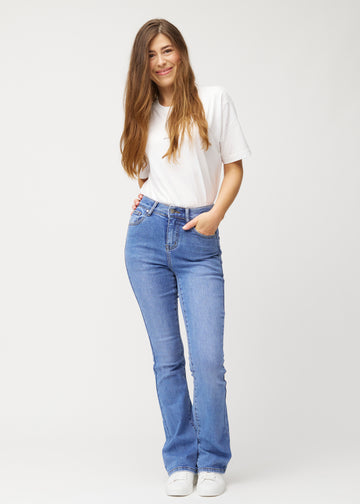 Blue mid-rise bootcut jeans in Rivers. Full-length view of a model wearing the jeans.