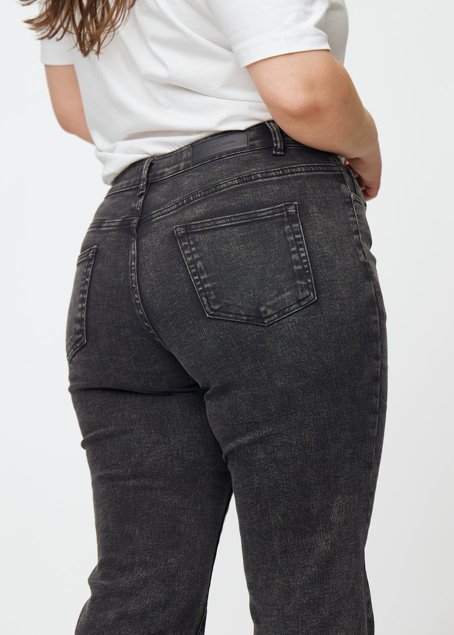 Dark grey mid-rise bootcut jeans in Shadows. Close-up back view on a plus-size model, showing the details.