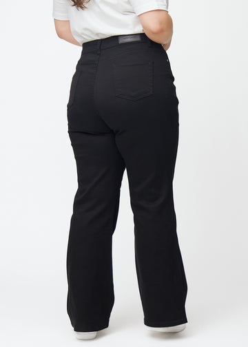 Black high-waisted bootcut jeans seen from the back on a plus-size model, so the full product can be seen.