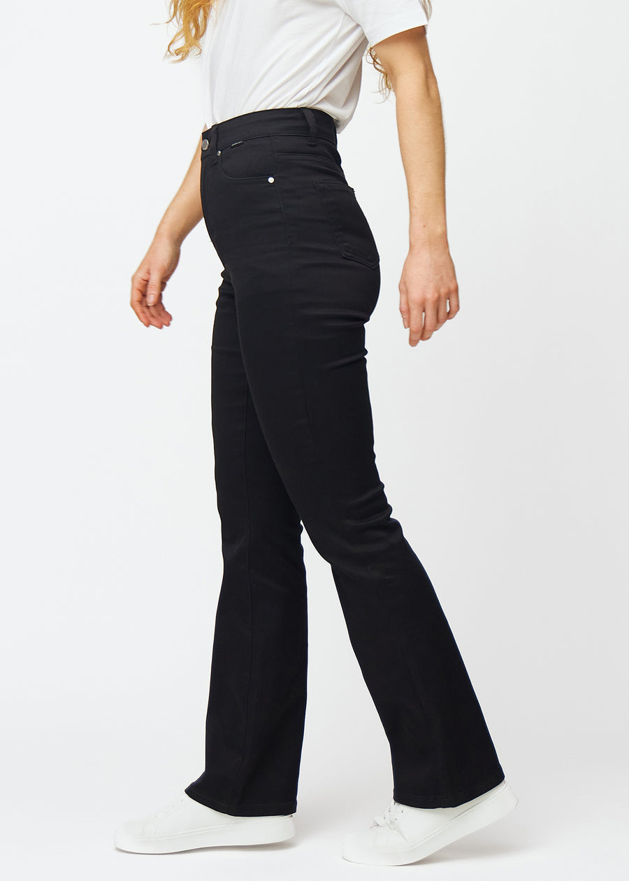 Black high-waisted bootcut jeans seen from the side on a model.