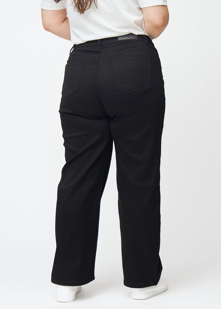 Black high-waisted jeans, which are fitted at the waist and have a loose fit with width down the leg, shown from the back on a plus-size model so you can see the full product.