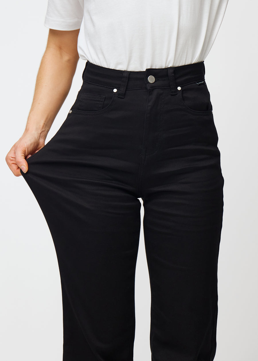 The model stretches the jeans at the thigh to show the stretch.
