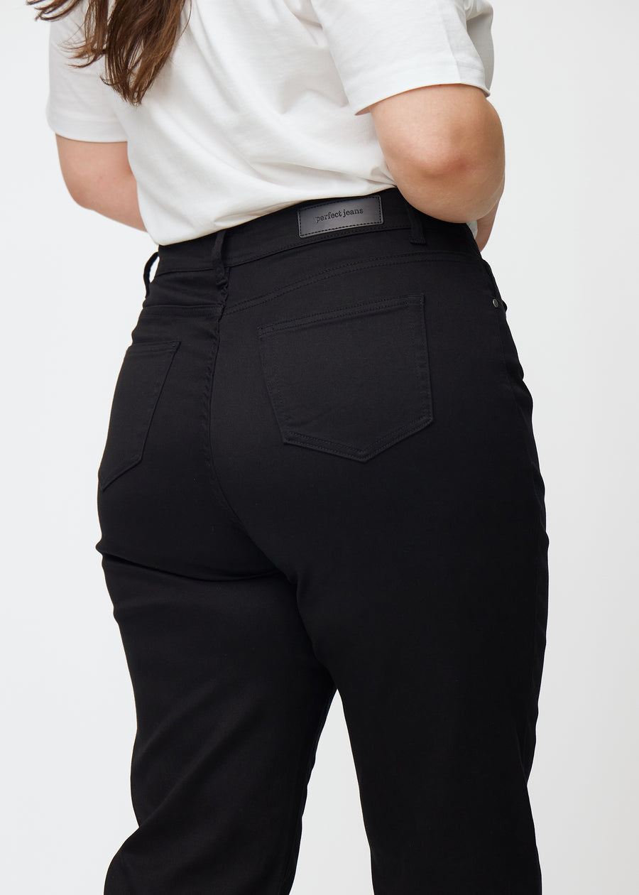 Black high-waisted regular jeans seen from the back in close-up on a plus-size model to show details.