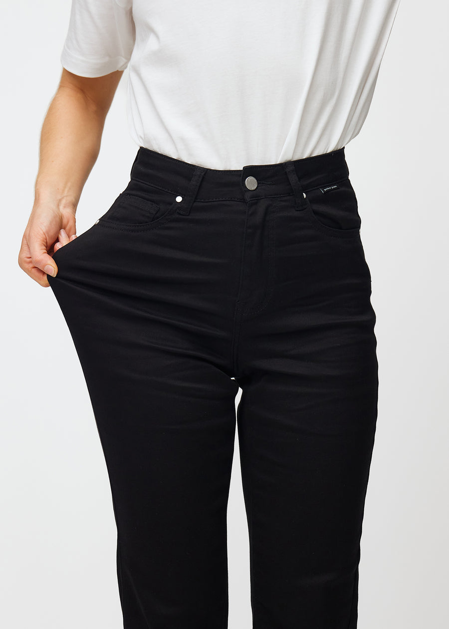 The model stretches the jeans at the thigh to show the stretch.