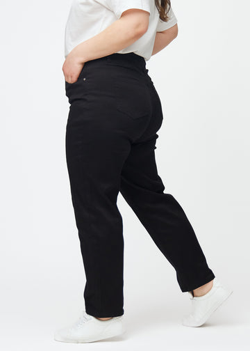 Black high-waisted regular jeans seen from the side on a plus-size model.
