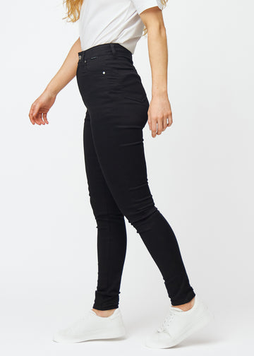Black high rise skinny jeans for women in the color Ravens are seen from the side on a model.