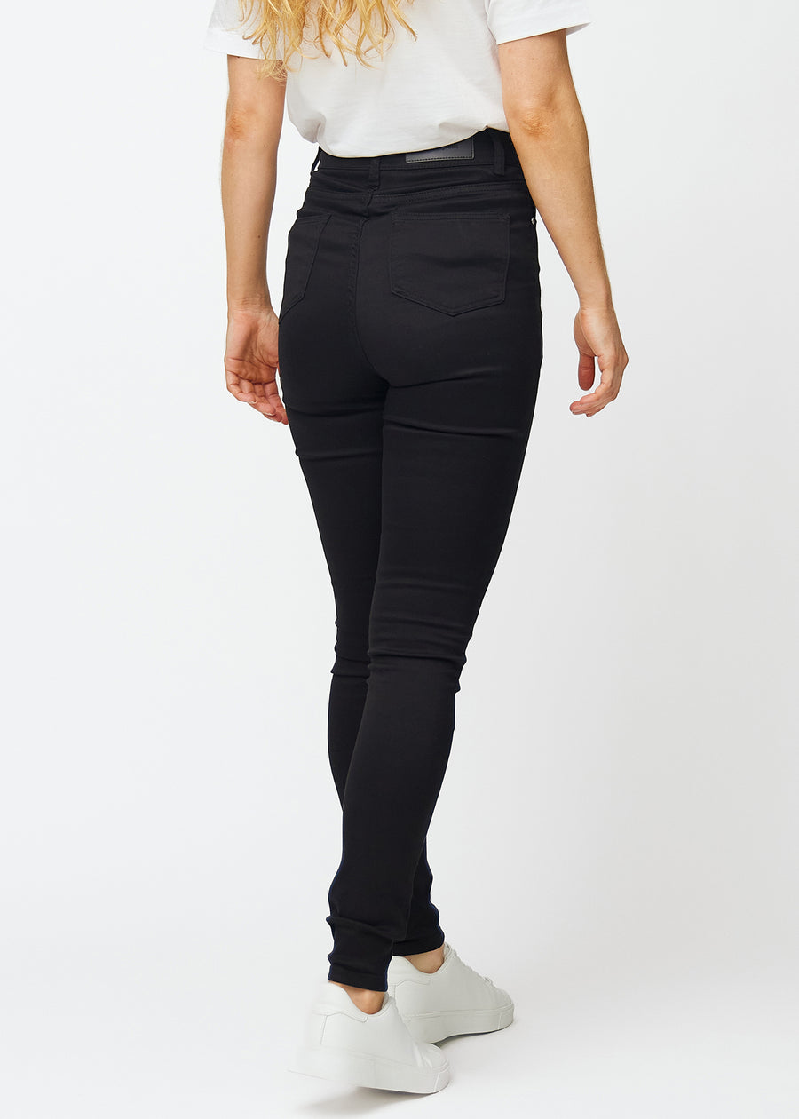 Black jeans with a high waist for women in the color Ravens with skinny fit are seen from the back on a model.