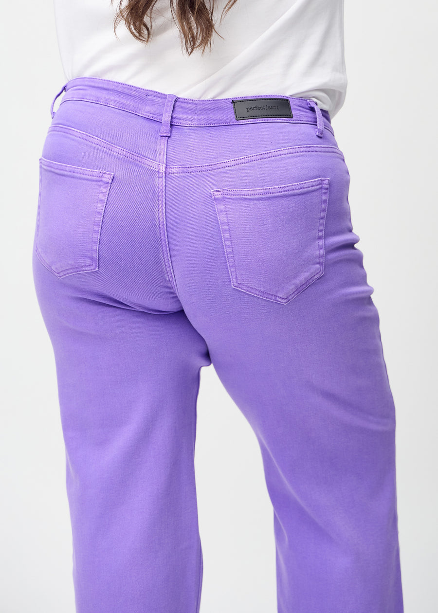 Loose jeans for women in purple, color Lavenders. Close-up from behind on a plus-size model, showing the fit and details.