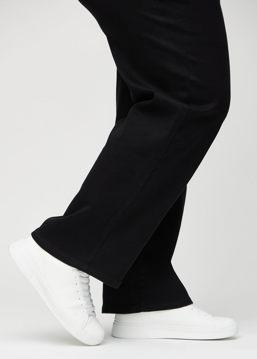 Loose jeans for women in black, color Ravens. Close-up at the ankles on a plus-size model, showing the wide leg openings.