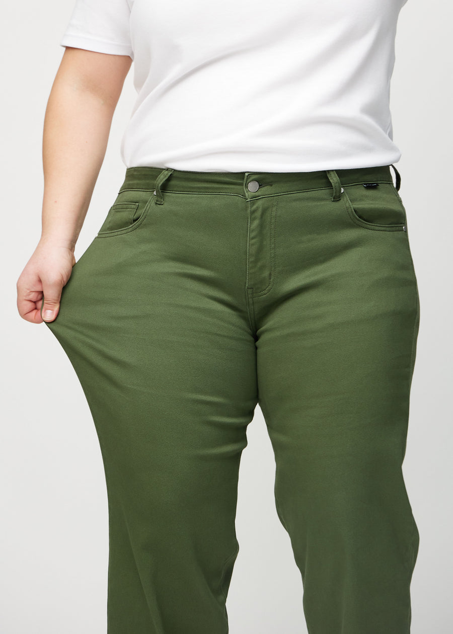 Loose jeans for women in dark green, color Renewals. A plus-size model stretches the denim at the thigh to show the fabric&
