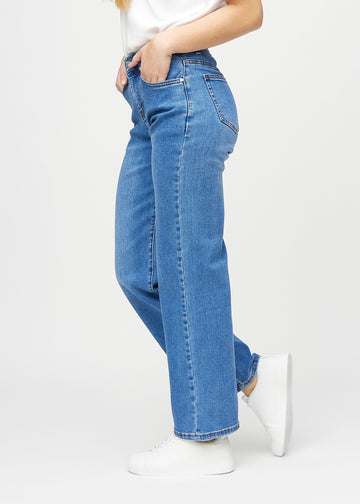 Loose jeans for women in blue, color Rivers. Side view on a model, showing the loose fit.
