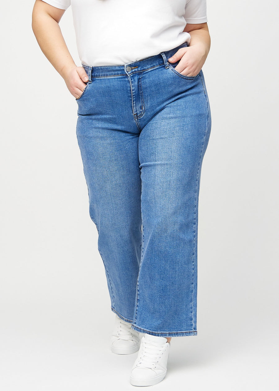 Loose jeans for women in blue, color Rivers. Front view on a plus-size model, showing the roomy, wide-leg fit.