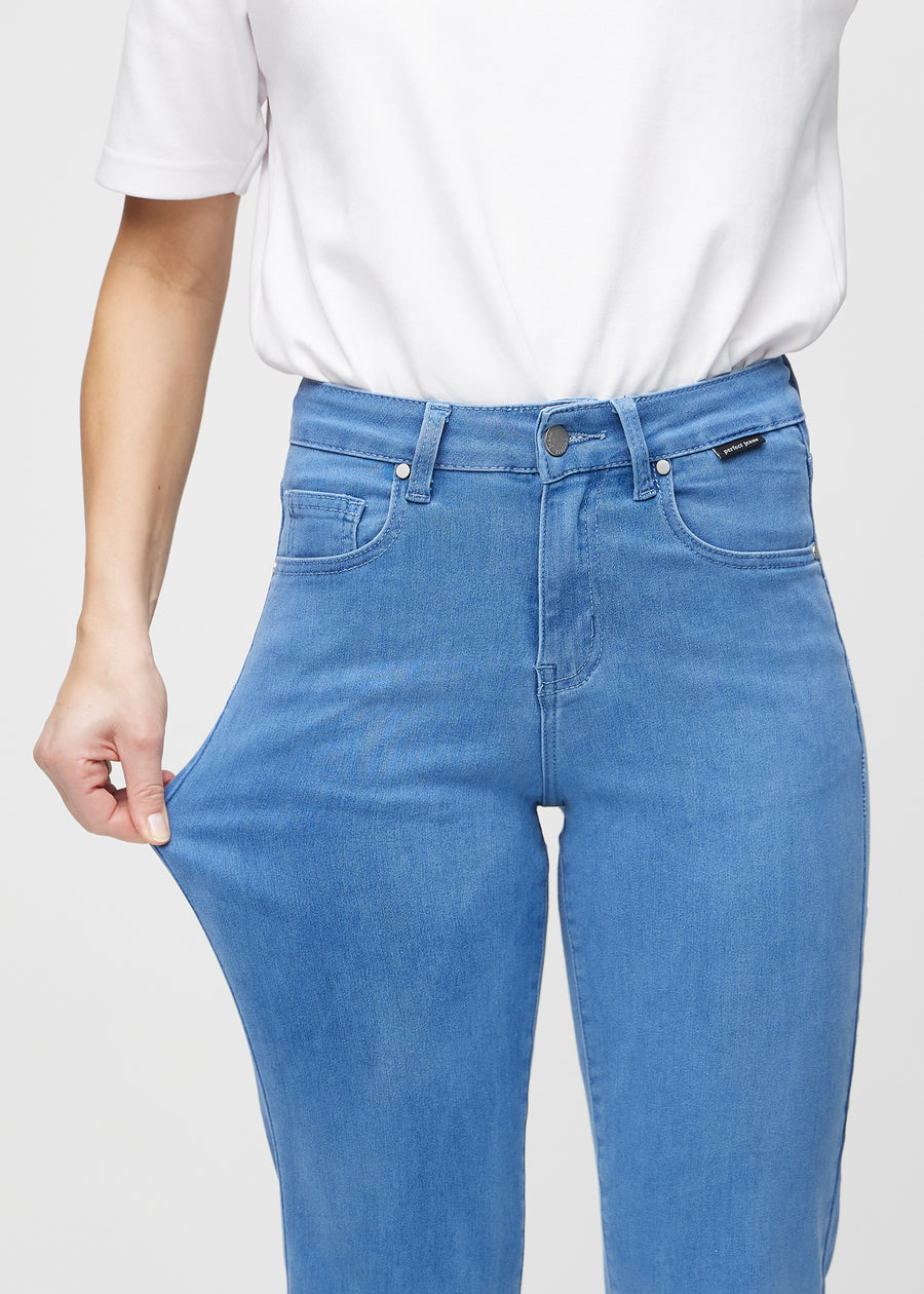 Regular jeans for women in blue, color Geraniums. A model stretches the fabric at the thigh to show its stretch.